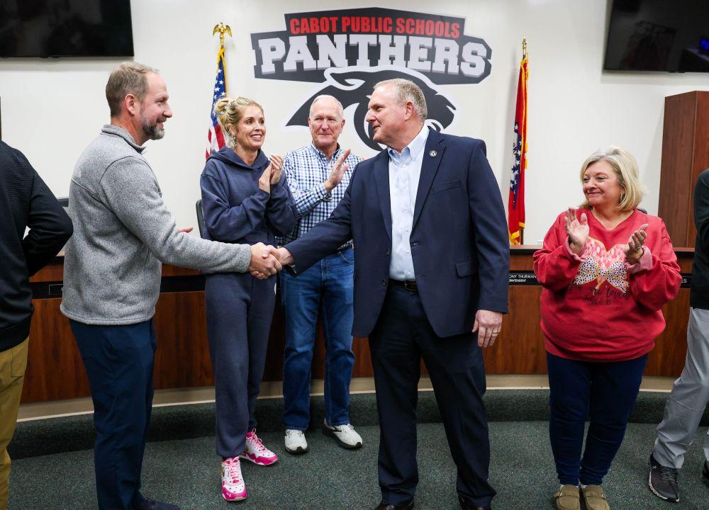 Mr. Byrd in the board room shaking Dr. Hertzog's hand